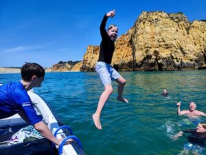 Customers swimming and jumping off boat